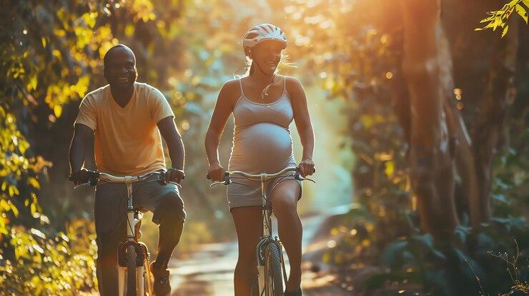 Un couple de parents avec une femme enceinte à vélo en fôret